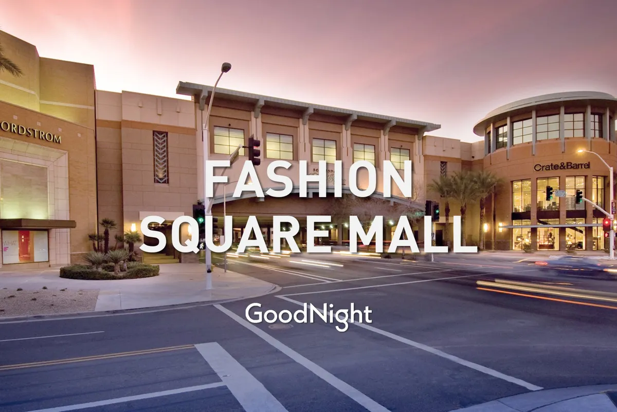 Bustling exterior with recognizable storefronts, palm trees, and people enjoying the vibrant atmosphere. Evening lighting and traffic signals add a sense of a lively urban environment, perfect for after-work dining or shopping. The energy of the scene suggests convenience and access to amenities for business travelers.